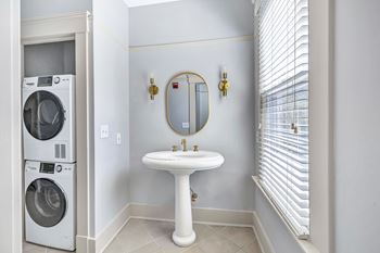 A white bathroom with a washer and dryer in the corner.